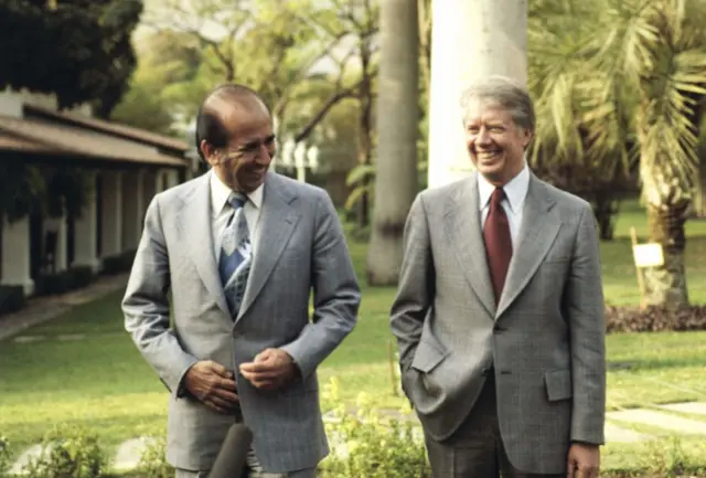 Carlos Andrés Pérez (d) y Jimmy Carter caminan sonrientes por los jardines del palacio de Miraflores, en Caracas.