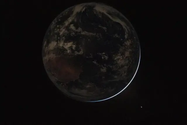 در حالی که زمین کاملا خورشید را می‌پوشاند، نورها در شب چشمک می‌زنند