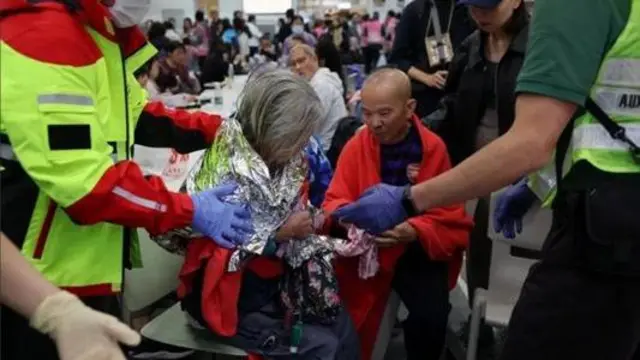 Літню жінку азійського походження везуть на каталці