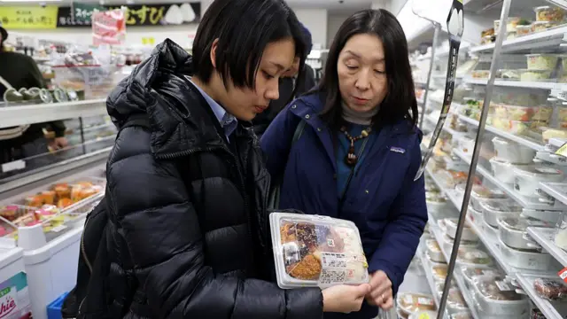 コンビニで売られている食品をチェックする井出留美氏（右）と森永理子氏