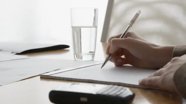 A desk with a phone and notepad