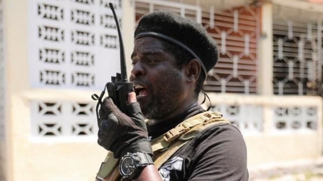 L'ancien officier de police Jimmy "Barbecue" Cherizier, chef d'une alliance de groupes armés, utilise un talkie-walkie après s'être adressé aux médias, à Port-au-Prince, Haïti, le 11 mars 2024.