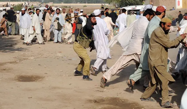 लाठी बरसाता पुलिसकर्मी 