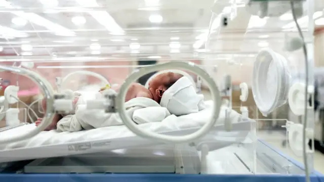 Newborn baby lying in incubator in a maternity hospital