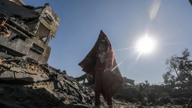 A Palestinian girl inspects the destroyed house of her family following an Israeli air strike in Al Maghazi refugee camp, central Gaza Strip, on 3 January 2025 - according to reports from the Hamas-run Ministry of Health in Gaza, at least nine members of the Abu Libda family were killed in an Israeli air strike on the refugee camp