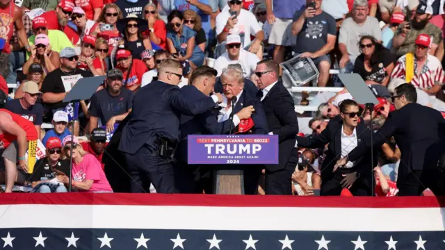 Trump sendo retirado do palco após tiros 