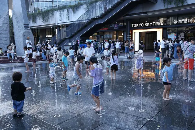 Anak-anak bermain di air mancur di Lapangan Solamachi di Kota Skytree Tokyo. Pusat Tokyo mencatat suhu tertinggi 33,8°C, menandai hari ke-11 suhu pertengahan musim panas bulan ini pada 28 Juni 2025 di Tokyo, Jepang.
