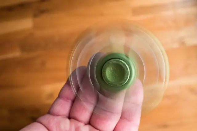 Un fidget spinner gira sobre una mano