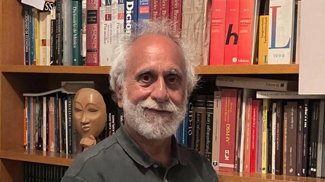 Mauro Mendes com sorriso contido em frente a estante de livros