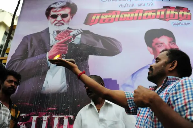 రజనీకాంత్ సినిమా పోస్టర్ ముందు పూజ చేస్తున్న అభిమానులు