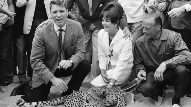 كاردينالي (وسط) إلى جانب الممثل بيرت لانكستر (يسار) في عرض فيلم "الفهد" من إخراج فيسكونتي، عام 1963