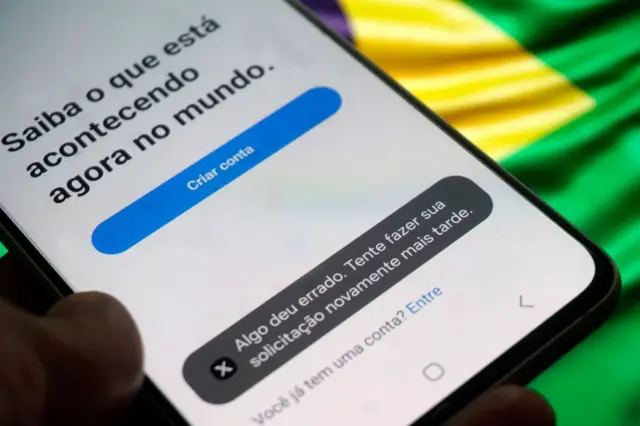 Celular com tela inicial do aplicativo X mostra mensagemsites de bolao'Algo deu errado' 