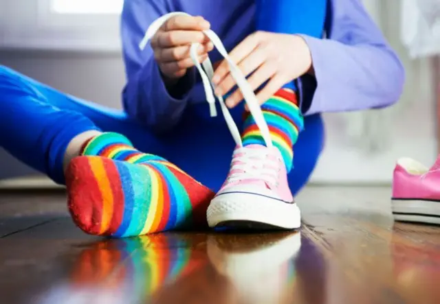 Un enfant en train de lacer ses chaussures