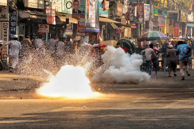 معترضان در حال فرار در خیابانی در دکا پایتخت بنگلهدیش دیده میشوند که ظاهرا پس از پرتاب گاز اشکآور توسط پولیس در حال گریز هستند.
