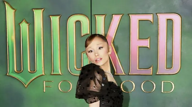 Аріана Гранде на тлі постеру до фльму "Чародійка 2"