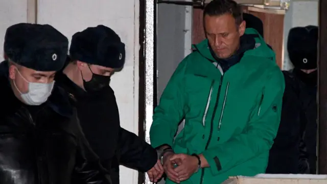 Alexei Navalny is escorted out of a police station on January 18, 2021, in Khimki, outside Moscow