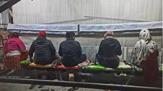 गलैँचा कारखानामा काम गर्दै मजदुरहरू।