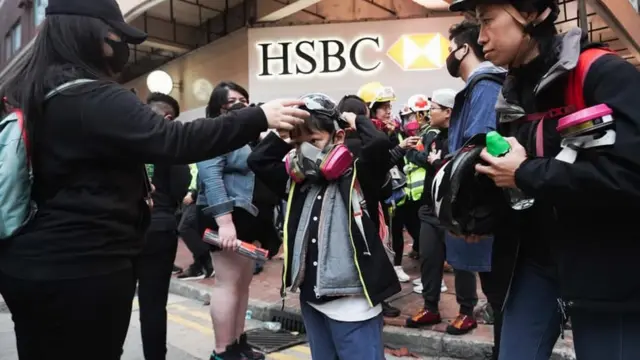 一些父母带同小孩参与游行，得悉附近有催泪弹后为孩子带上防毒面具。