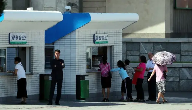 2018년 9월 18일 평양 순안공항에서 시내로 향하는 거리 매점에서 북한 주민들이 청량음료를 사기 위해 줄지어 서 있다.