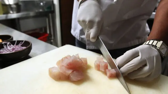 Cocinero cortando pescado