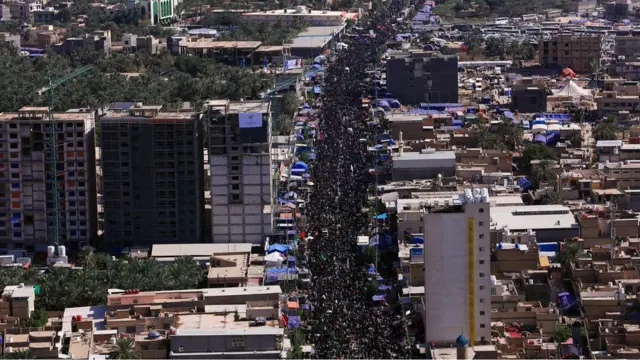 حشود من الزائرين في أحد شوارع مدينة كربلاء متوجهين لزيارة مرقد الحسين سيرا على الأقدام