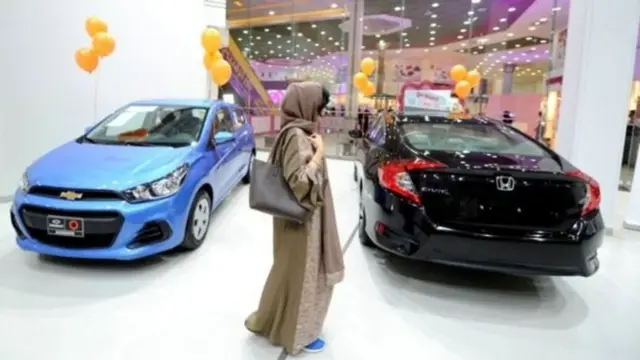 કારના શૉરૂમમાં કારને નિહાળતી મહિલા