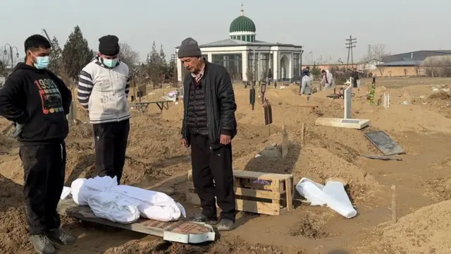 Тургундар көрүстөндөгү жакындарынын сөөгүн мүрзөнүн ичкери тарабына көчүрүп жатышат.