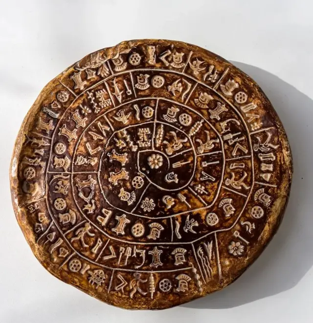 Il s'agit d'une réplique du disque de Phaistos, un célèbre artefact en argile de la civilisation minoenne.