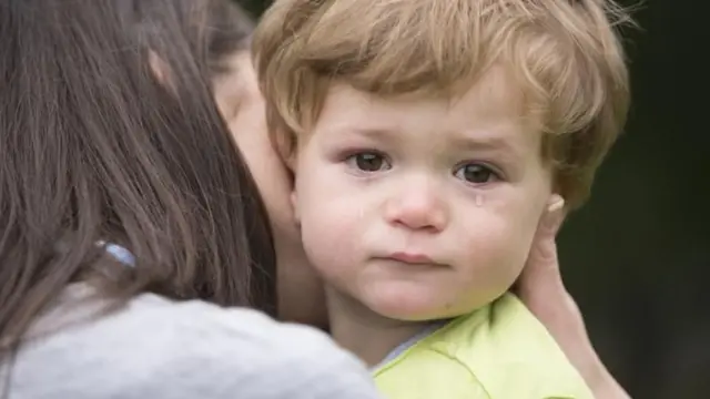 Criança chorando no colo