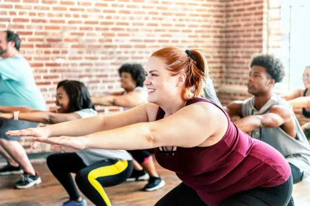 Un grupo de hombres y mujeres practicando yoga