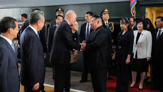 Ju Ae yagaragaye inyuma ya se ubwo yakirwaga kuri sitasiyo ya za Gariyamoshi i Beijing bahageze ku wa kabiri