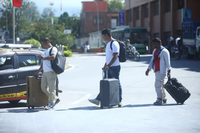 काठमाण्डूको त्रिभुवन अन्तर्राष्ट्रिय विमानस्थलबाट विदेश यात्रामा जान लागेका जस्ता देखिने तीन युवाहरू