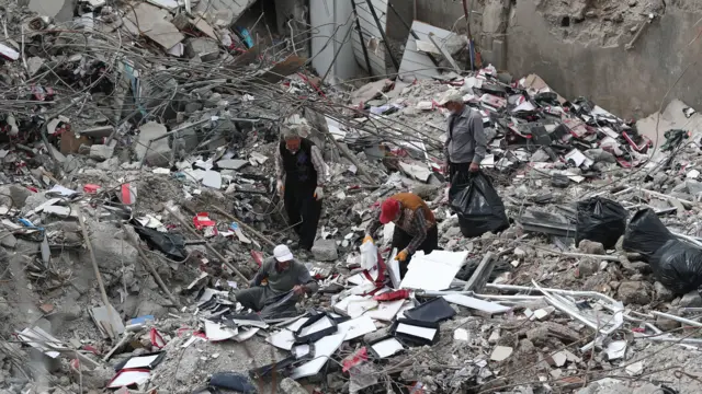 Pracownicy zbierają przydatne resztki swoich rzeczy z zawalonych sklepów w przededniu Ramadanu, po potężnym trzęsieniu ziemi w Kahramanmaras w Turcji, 22 marca 2023 r.