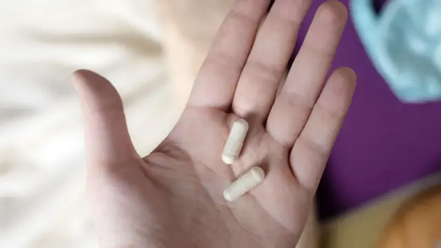 人手上捧著兩顆褪黑激素膠囊