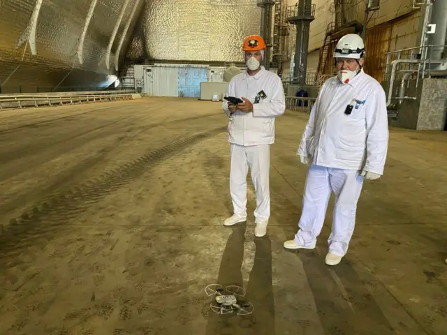Foto de Doroshenko de pie junto a un compañero de trabajo dentro del domo que protege al reactor 4 de la planta nuclear de Chernóbil.