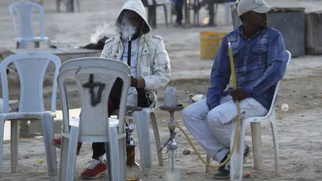 Some young men wey dey enjoy shisha smoke.