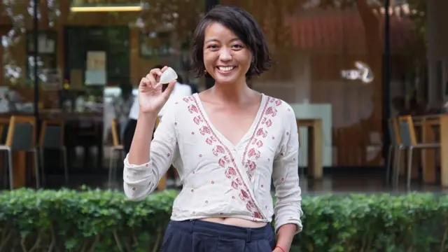 Woranuch Suksaeng holds up a menstrual cup that she's used for a year.