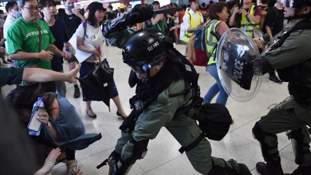 警方在地铁站内，用警棍制服部分人士。