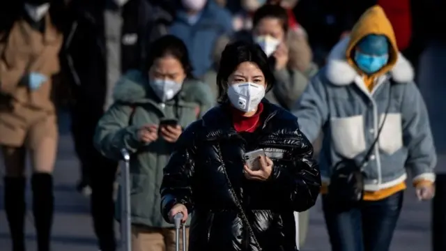 Travellers wearing facemasks arrive from various provinces at the Beijing Railway Station on February 3, 2020