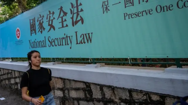 Pedestrians walks past a government-sponsored advertisement promoting a new national security law on June 30, 2020 in Hong Kong