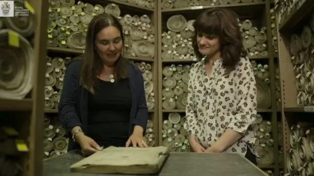 นางแคลร์ เคนนัน (ซ้าย) ผู้จัดหลักสูตรออนไลน์เรื่องขบวนการสิทธิสตรี ในห้องเก็บเอกสารต้นฉบับกฎหมายของรัฐสภาแห่งสหราชอาณาจักร