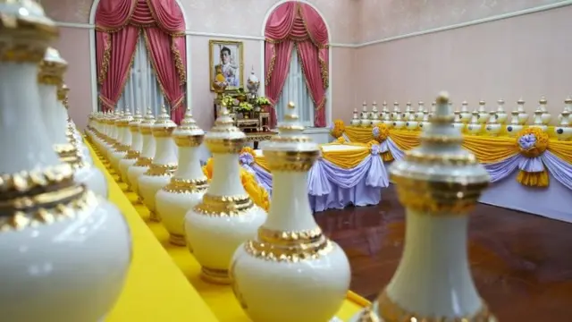 Una imagen del rey de Tailandia, Maha Vajiralongkorn, se ve entre las vasijas que contienen agua sagrada para la ceremonia de coronación en el Ministerio del Interior en Bangkok, Tailandia.
