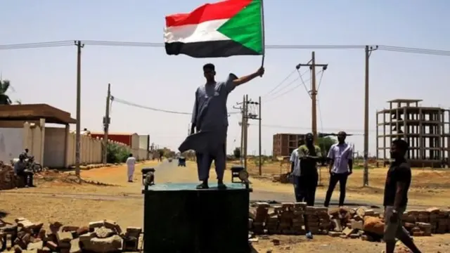 One sudanese protester stand ontop barricade for Khartoum on Wednesday