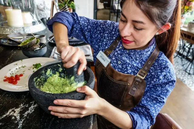 Una mujer prepara guacamole