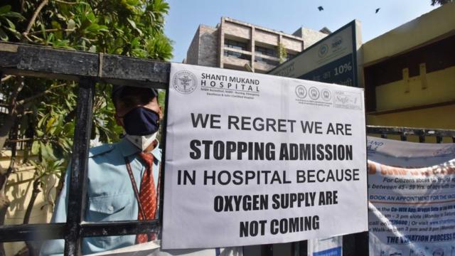 Aviso público pendurado em frente ao Hospital Shanti Mukund notificando a falta de leitos UTI, em 22 de abril de 2021 em Nova Delhi, Índia