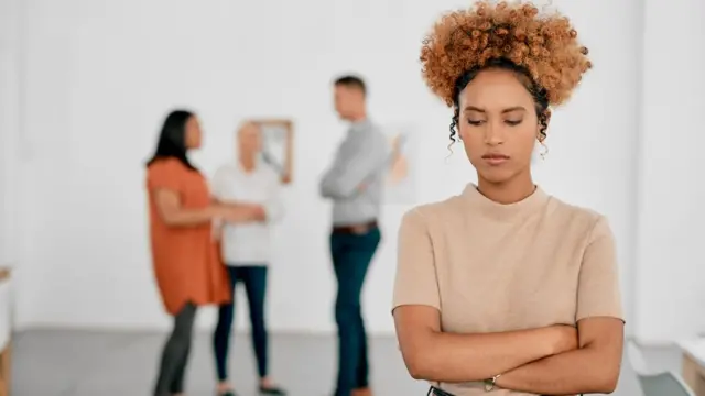 Femme au premier plan avec trois personnes derrière elle.
