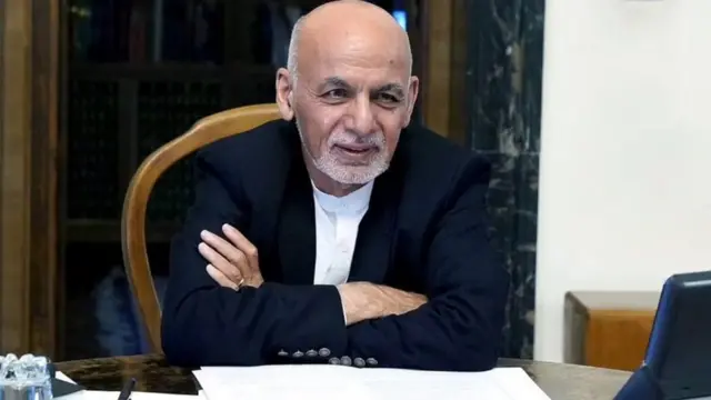 اشرف غنی با عکسی از او در پشت میز کارش در ارگ ریاست جمهوری