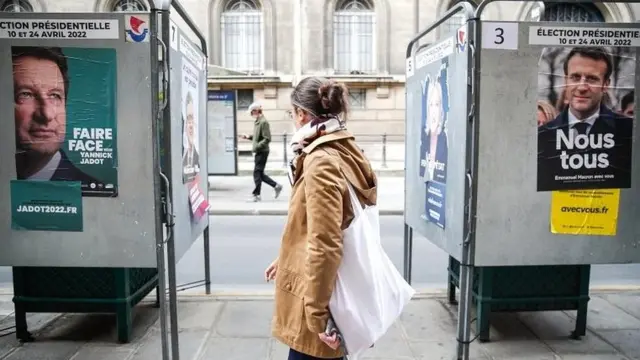 A person walks past posters of French presidential candidates in Paris, France, on 29 March 2022