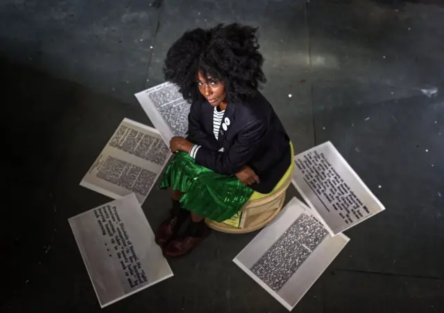 Elsa James entourée de coupure des journaux sur la Princesse Dinobolu