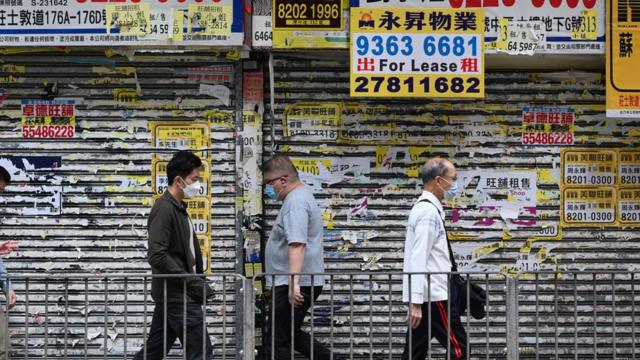 香港市民走过一家已倒闭的商店（19/10/2022）